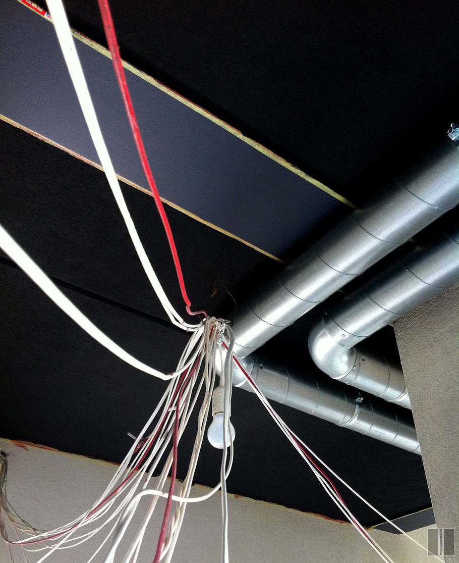 Koridoriuje tamsios lubos ir metaliniai ortakiai laidams paslėpti bei apšvietimui sumontuoti